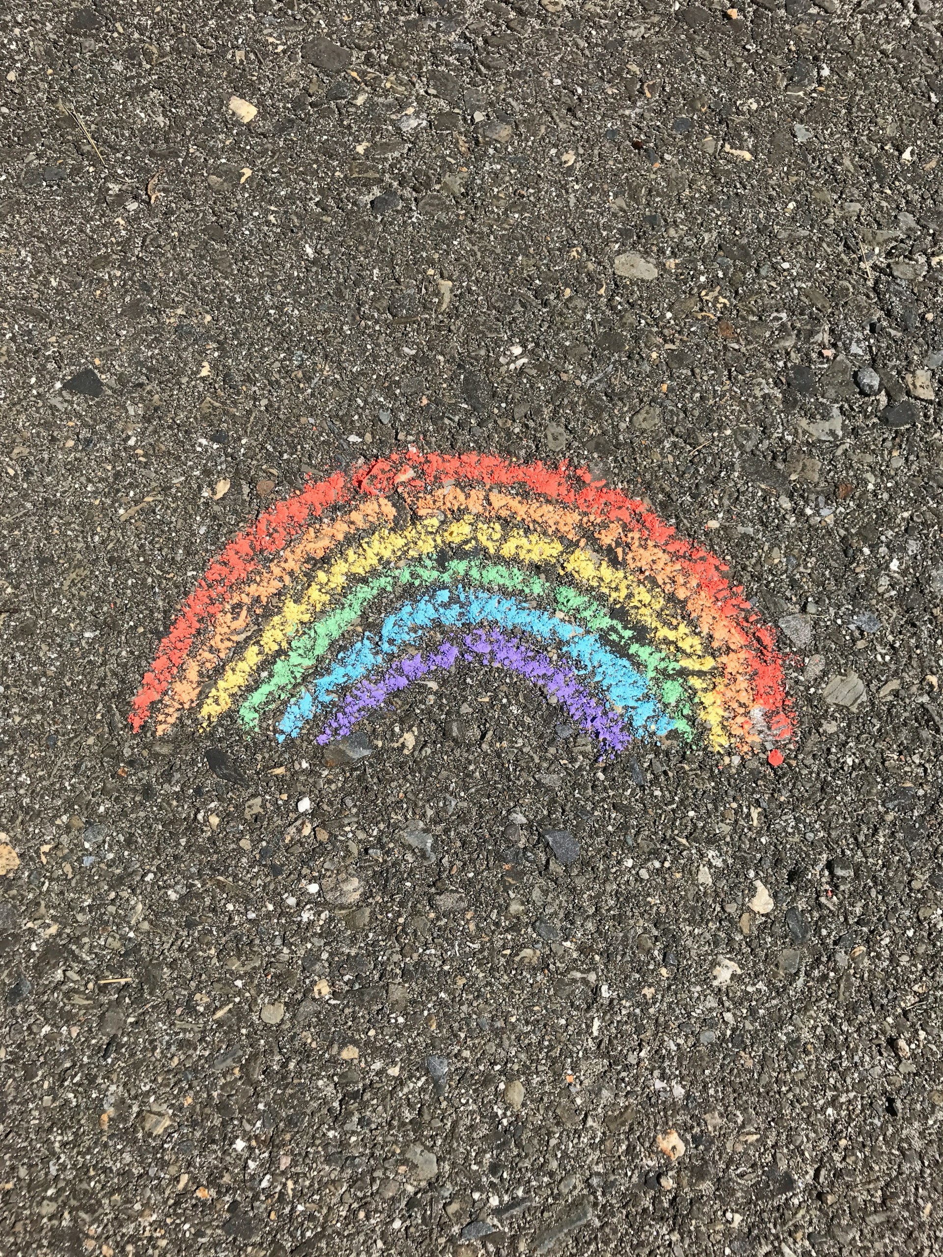 Photo of a simple sidwalk chalk drawing of a rainbow