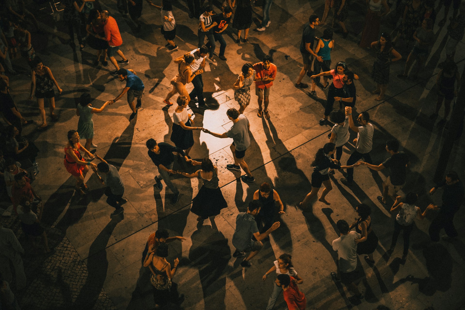 Dramatically lit photo of many couples dancing from above