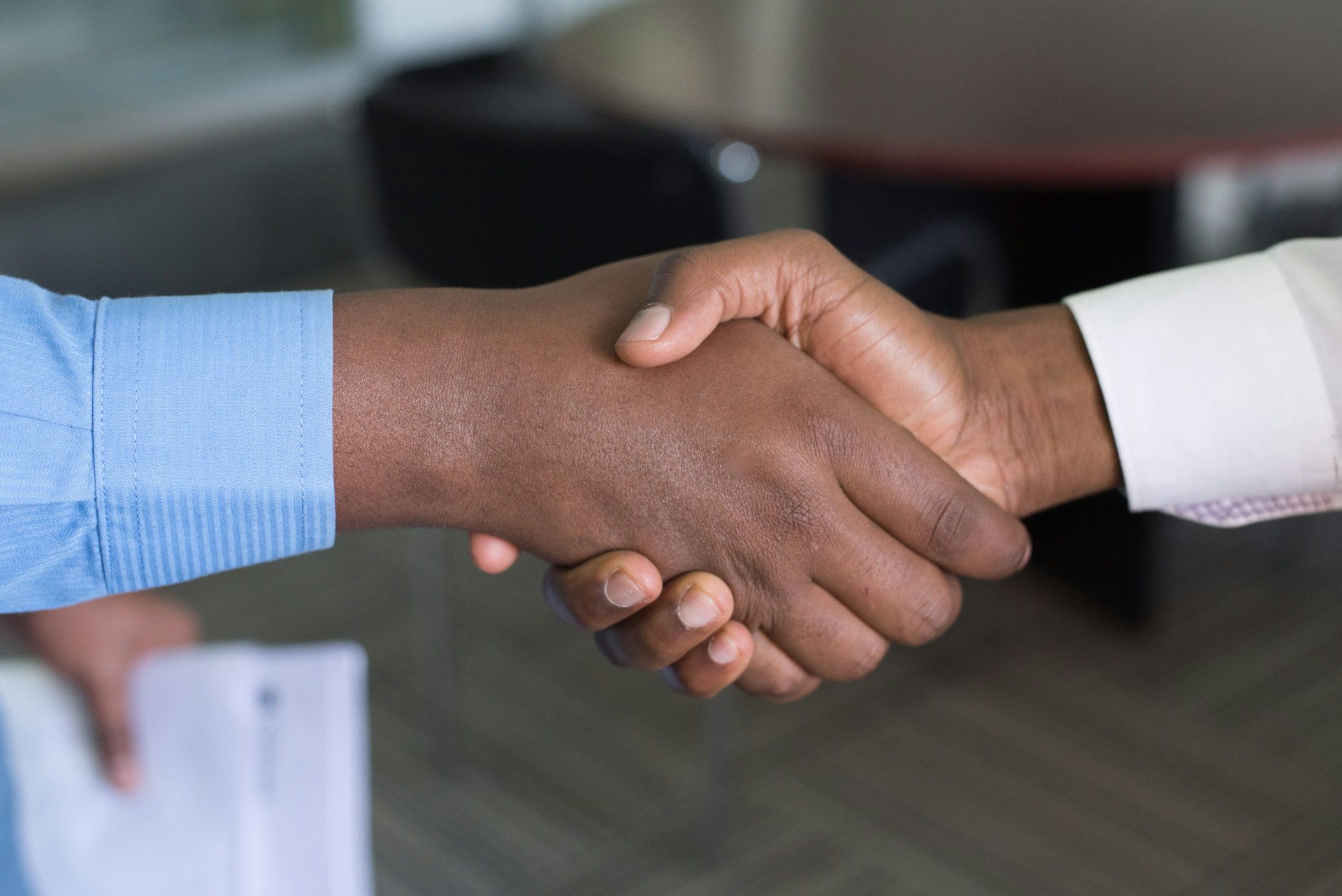 Photo of two hands engaged in a handshake.