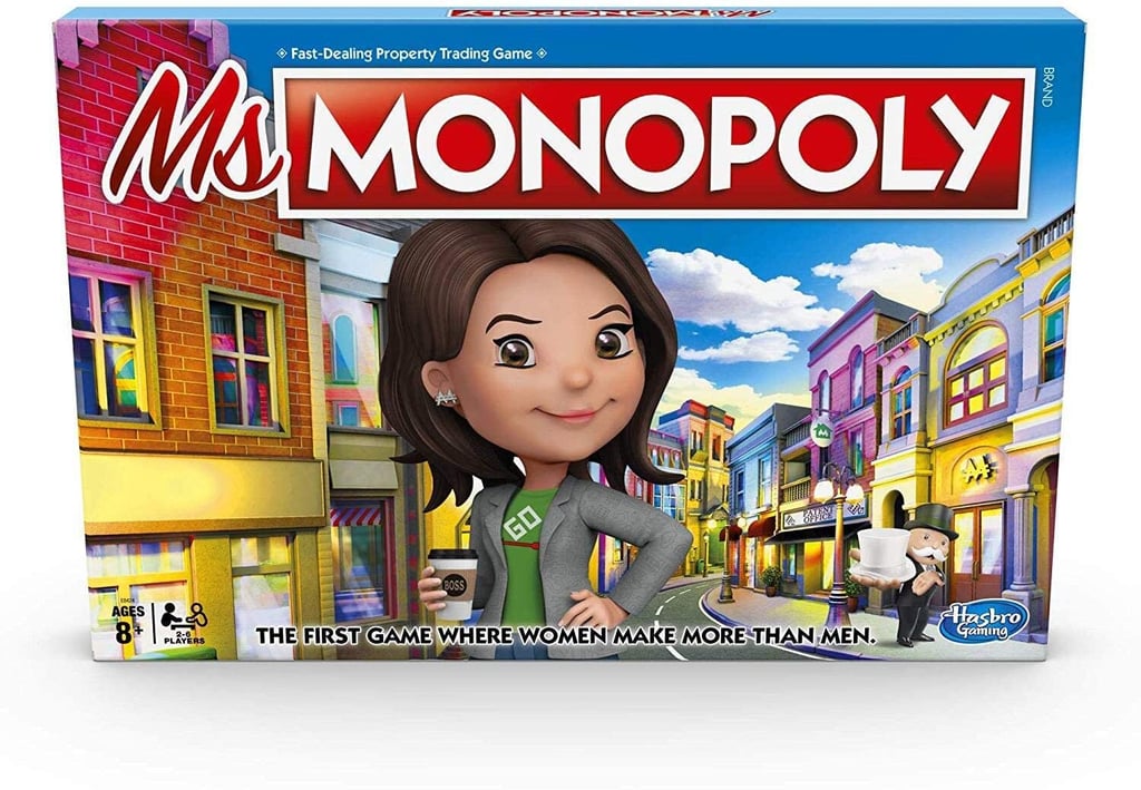 Photo of a board game box with large text 'Ms Monopoly'. Image is a cartoonish illustration of a woman in a blazer holding a cup of coffee standing on a busy commercial street.