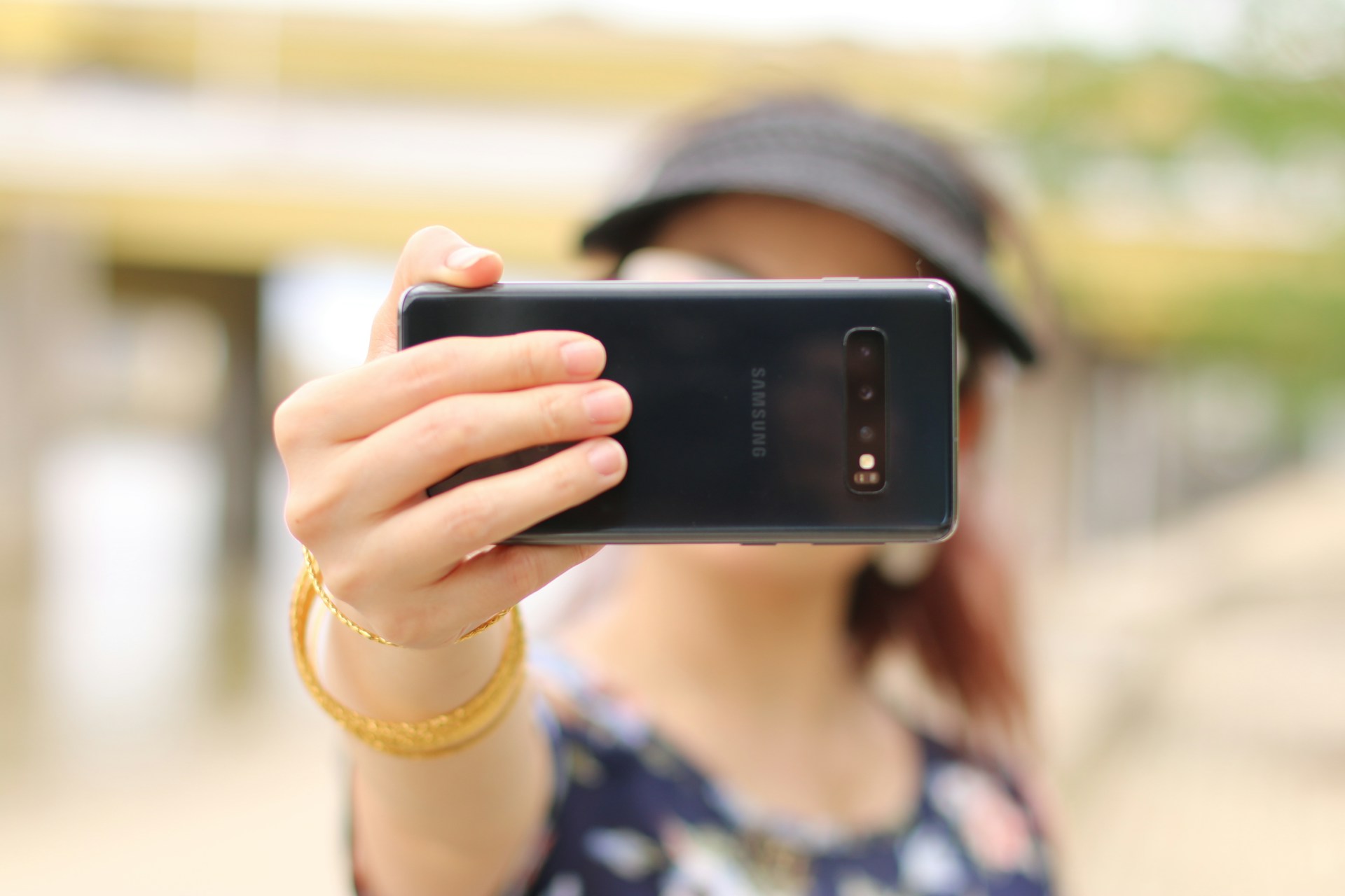 A photo of a person taking a selfie. Their phone is the only thing in focus, and it is covering their face.