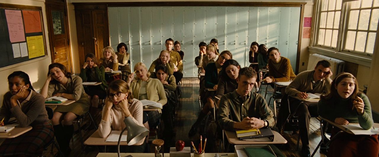 Photo of a group of students in a classroom from the perspective of a teacher. The students look variously confused, bored, and distracted. (Still from Across the Universe, 2007)