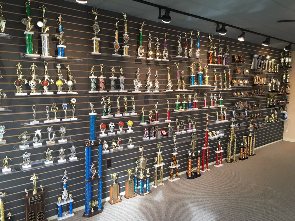 The wall of a trophy shop showing a wide selection of sports trophies